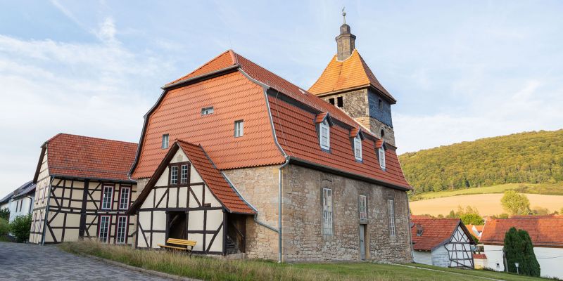 Dorfansicht von Schnellmannshausen mit Kirche und Fachwerkhäusern.