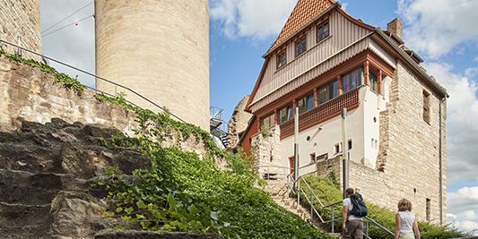 Aufstieg zur Burg Normannstein mit Burgturm und Restaurantgebäude